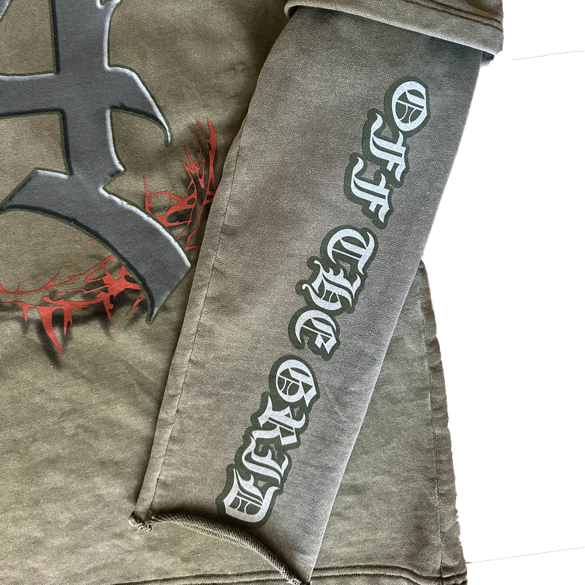 Close-up of the distressed sleeves effect and "Off The Grid" branding text printed on the sleeve.
